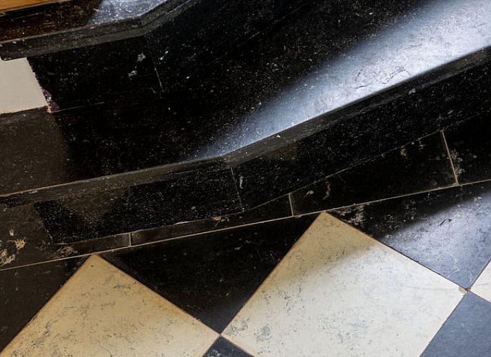 Stilvolles Esszimmer im Ferienhaus in Sint-Pauwels, Ostflandern, mit Holzmoebeln und Betonwaenden.