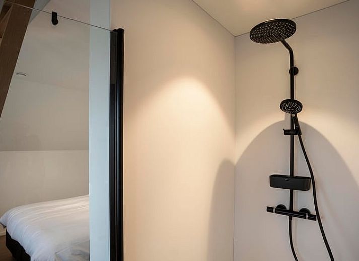 Moderne Kueche eines Ferienhauses in Sint-Pauwels, Belgien, mit schlichtem Design und warmen Farbtoenen.