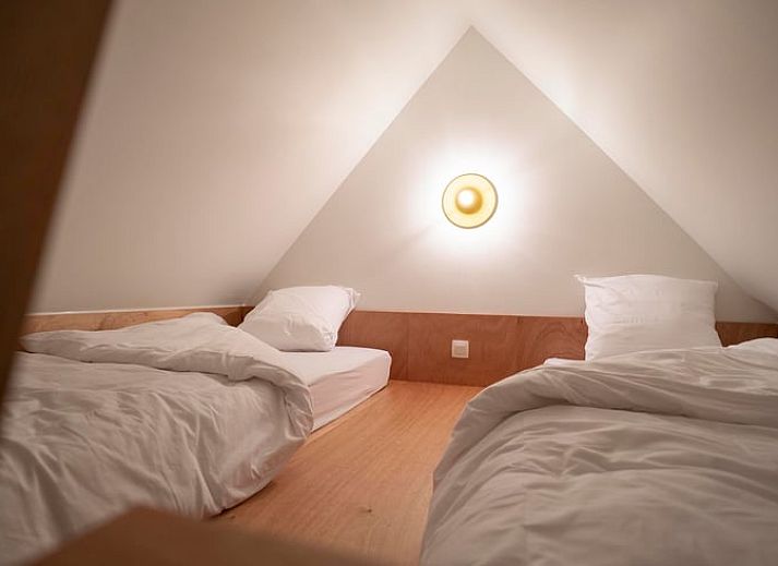 Moderne Kueche eines Ferienhauses in Sint-Pauwels, Belgien, mit schlichtem Design und warmen Farbtoenen.