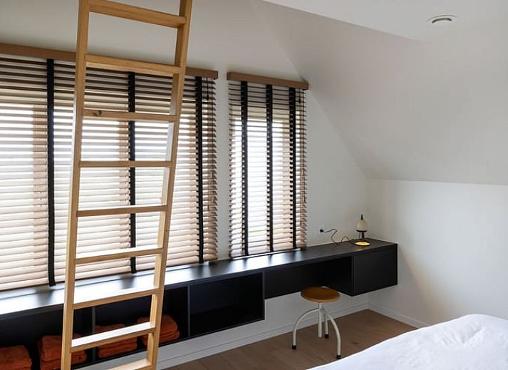 Moderne Kueche eines Ferienhauses in Sint-Pauwels, Belgien, mit schlichtem Design und warmen Farbtoenen.