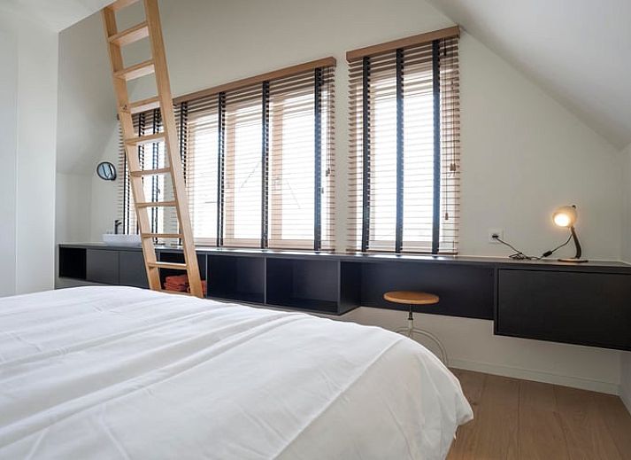 Moderne Kueche eines Ferienhauses in Sint-Pauwels, Belgien, mit schlichtem Design und warmen Farbtoenen.