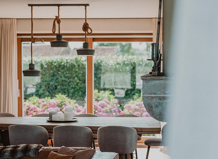 Stijlvolle eetkamer in Villa Noortem, een vakantiehuis in Maldegem, Oost-Vlaanderen, met uitzicht op de tuin en veel natuurlijk licht.