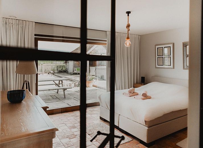 Stijlvolle eetkamer in Villa Noortem, een vakantiehuis in Maldegem, Oost-Vlaanderen, met uitzicht op de tuin en veel natuurlijk licht.