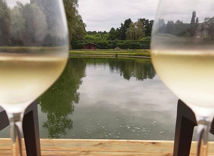 Offener Wohn- und Schlafraum im Cottage in Moerzeke, Ostflandern, mit Blick auf die gruene Landschaft.
