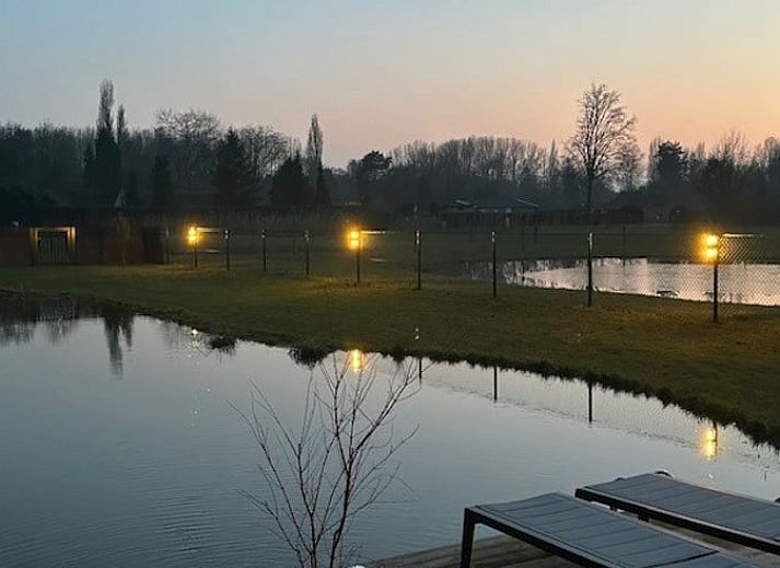 Ruhige Umgebung im Ferienhaus in Moerzeke, Ostflandern, mit Teich und gruenen Feldern.