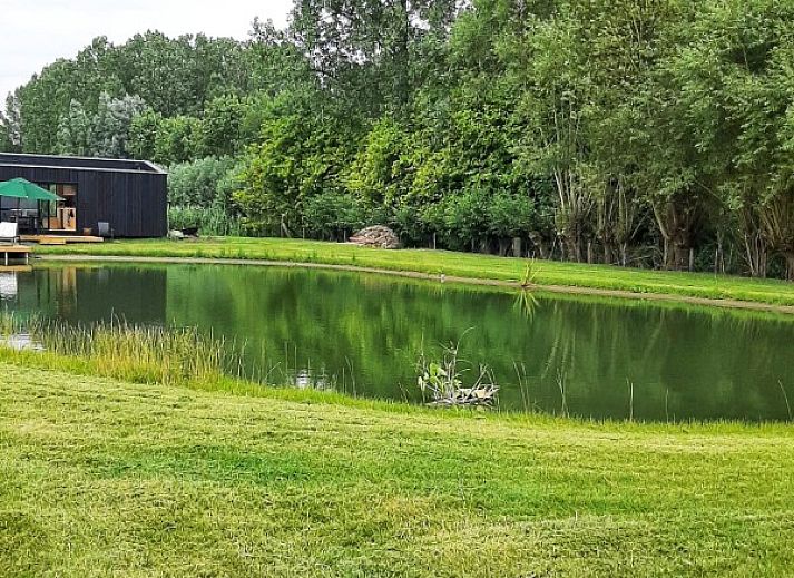 Bedroom in Black Pearl vacation home, Moerzeke, East Flanders, with large windows and views of nature.