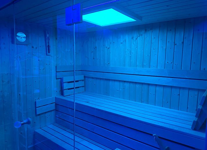 Cozy indoor area of Holiday Home Einzigartiger Wellness-Bauernhof in Wichelen, East Flanders with fireplace and garden view.