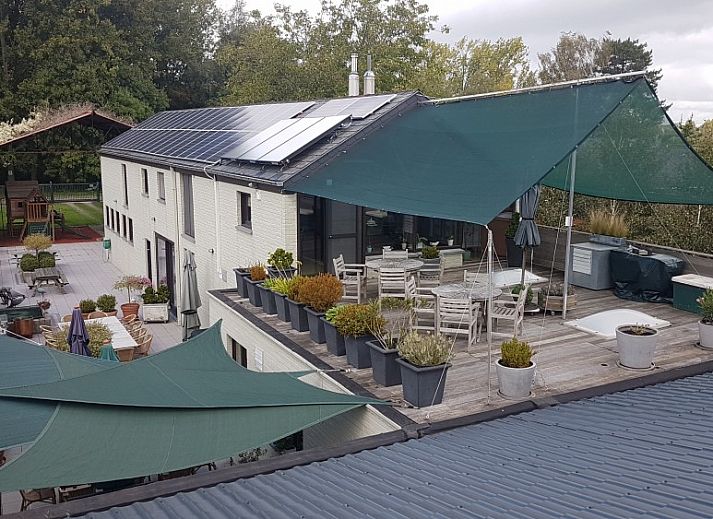 Veranda im Holiday home d'Eenaemsche Vierschaere in Oudenaarde, Ferienhaus mit Holzmoebeln und Pflanzen.