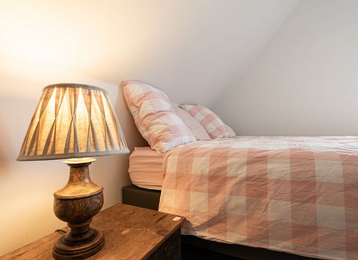 Gemuetliches Wohnzimmer in Cottage in Sint-Laureins, Ferienhaus in Ostflandern, mit bequemer Sitzecke und Blick auf die gruene Landschaft.