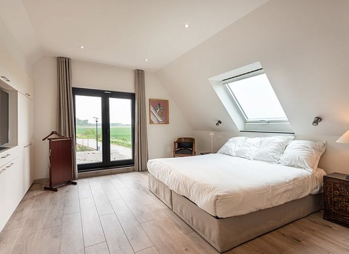 Gemuetliches Esszimmer von Huisje in Sint-laureins, einem Ferienhaus in Sint-Laureins, Ostflandern, mit Blick auf die gruene Landschaft.