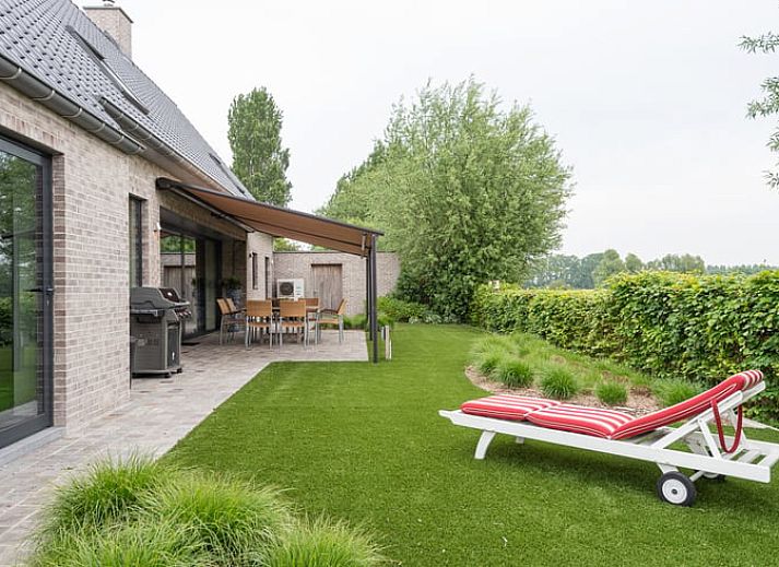 Gemuetliches Esszimmer von Huisje in Sint-laureins, einem Ferienhaus in Sint-Laureins, Ostflandern, mit Blick auf die gruene Landschaft.