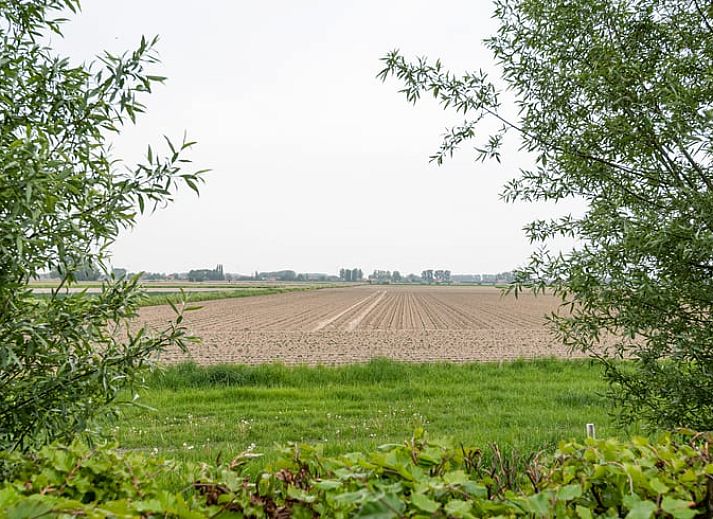 Moderne Kueche in Cottage in Sint-laureins, einem Ferienhaus in Sint-Laureins, Ostflandern, Belgien, mit schlichten weissen Schraenken und einer grosszuegigen Arbeitsflaeche.