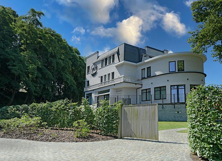 Moderne keuken in Villa Col 38, een vakantiehuis in Kluisbergen, Oost-Vlaanderen, Belgie, met ruim kookeiland en uitzicht op de tuin.