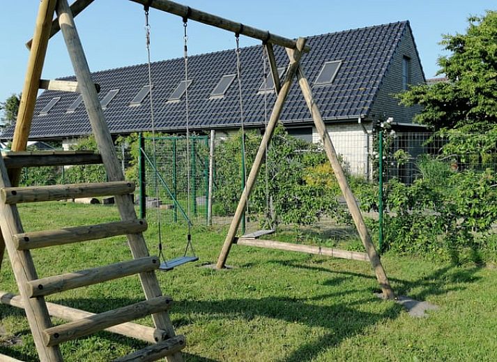 Stilvolle Einrichtung des Ferienhauses in Sleidinge mit roten Sofas und einem Flachbildfernseher in Ostflandern, Belgien.