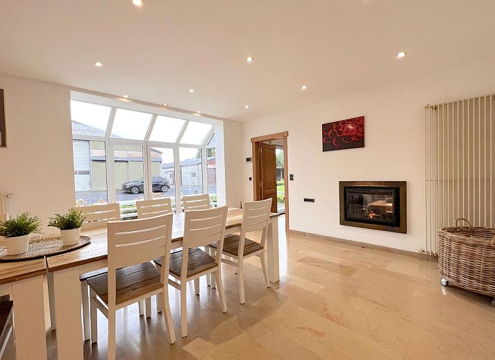 Gemuetliches Wohnzimmer im Ferienhaus Zingem mit grossen Fenstern und bequemen Sofas.