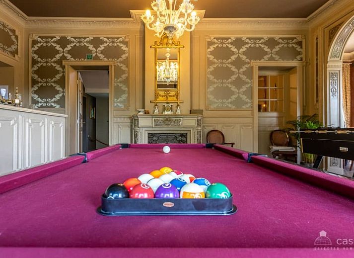 Gemuetliches Wohnzimmer im Ferienhaus Boeckhaege, Ronse, Ostflandern, mit Kamin und luxurioesem Kronleuchter.