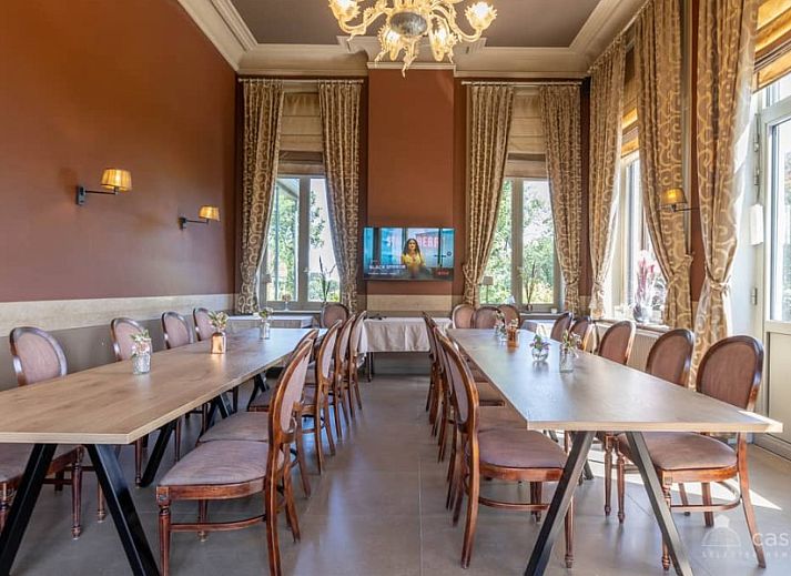 Gemuetliches Wohnzimmer im Ferienhaus Boeckhaege, Ronse, Ostflandern, mit Kamin und luxurioesem Kronleuchter.