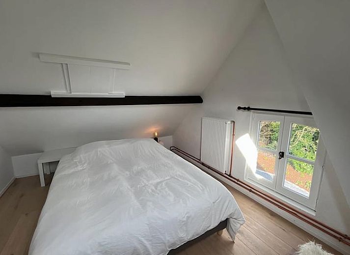 Gemuetliche Terrasse am Ferienhaus in Gavere Dikkelvenne, Ferienhaus in Dikkelvenne, Ostflandern, mit Holzstuehlen und Gruenpflanzen.