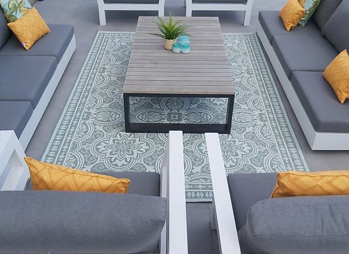 Geraeumige Terrasse des Ferienhauses in Merendree, Ostflandern, mit bequemen Sitzgelegenheiten und Gartenblick.