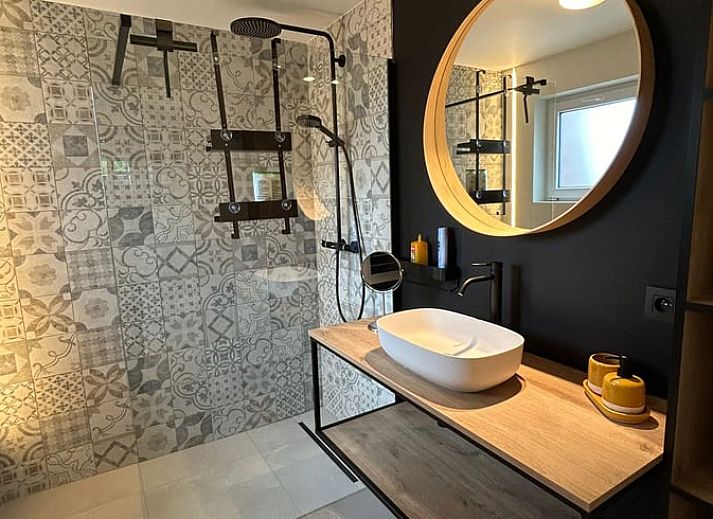 Gemuetliche Sitzecke im Ferienhaus in Merendree, Ostflandern, mit grossem Sofa und warmer Dekoration.