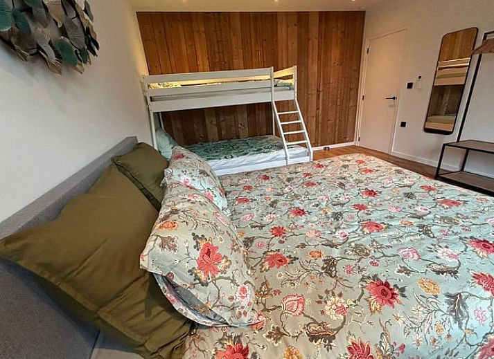 Gemuetliche Sitzecke im Ferienhaus in Merendree, Ostflandern, mit grossem Sofa und warmer Dekoration.