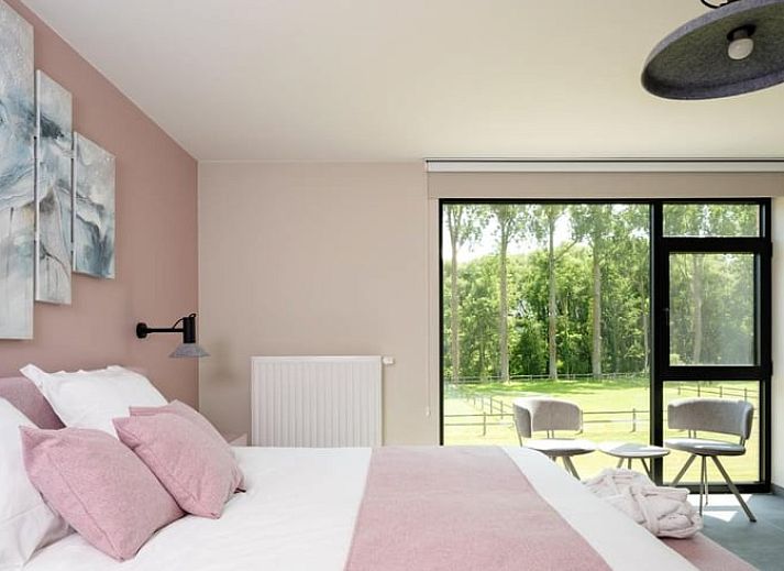 Sfeervolle slaapkamer in Vakantiehuis in Lennik, Vlaams-Brabant, met uitzicht op groene natuur.