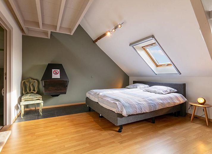 Gezellige woonkamer in vakantiehuis Alverwege, Merksplas, Antwerpen, met een warme haard en ruime zithoek voor ontspanning in een landelijke sfeer.