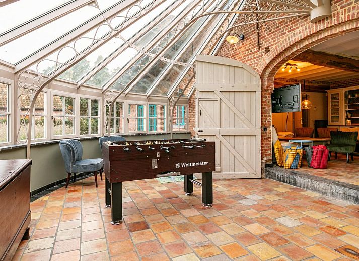 Gezellige eetruimte in vakantiehuis Alverwege, Merksplas, Antwerpen met rustieke houten balken en een ruime eettafel voor groepsdiners.