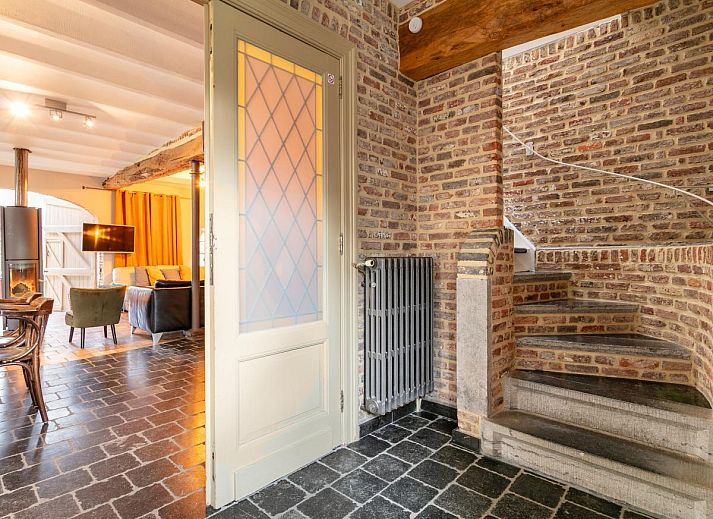 Gezellige eetruimte in vakantiehuis Alverwege, Merksplas, Antwerpen met rustieke houten balken en een ruime eettafel voor groepsdiners.