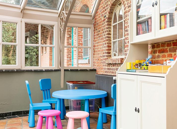 Gezellige eetruimte in vakantiehuis Alverwege, Merksplas, Antwerpen met rustieke houten balken en een ruime eettafel voor groepsdiners.