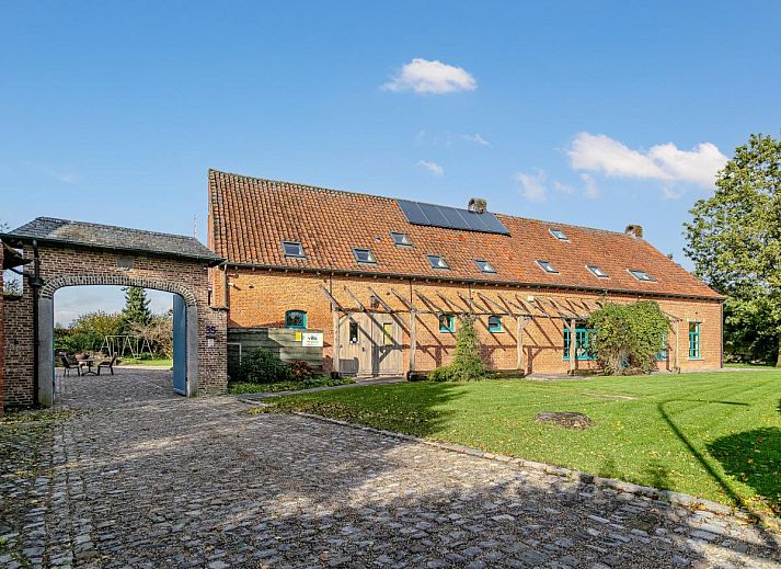 Gezellige eetruimte in vakantiehuis Alverwege, Merksplas, Antwerpen met rustieke houten balken en een ruime eettafel voor groepsdiners.