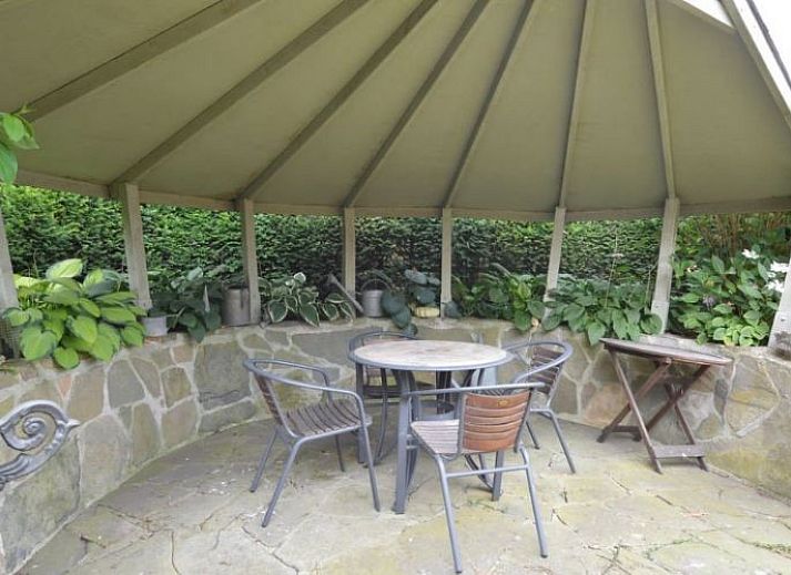 Sfeervolle woonkamer van Vakantiehuis Maison Paula in Merksplas, Antwerpen, met comfortabele zithoek en houten details.