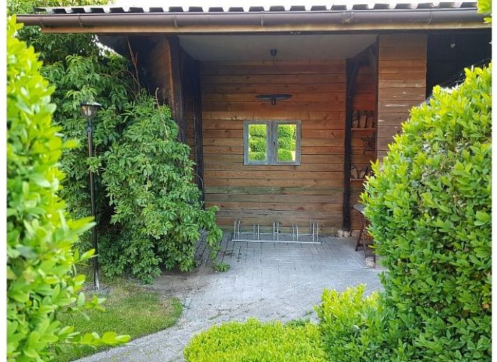 Sfeervolle woonkamer van Vakantiehuis Maison Paula in Merksplas, Antwerpen, met comfortabele zithoek en houten details.