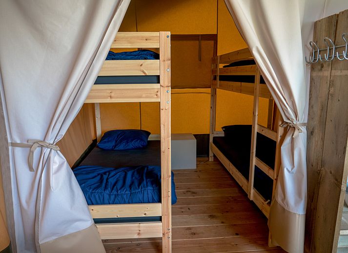 Entdecken Sie das gemuetliche Innere des Safari-Zeltes, einer Glamping-Lodge in Brecht, Antwerpen, ideal fuer einen rustikalen Urlaub.