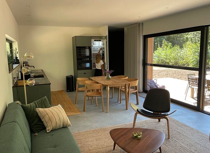 Zijaanzicht van Vakantiehuis in Gierle, gelegen in de natuur van Antwerpen, Belgie met houten omheining en terras.