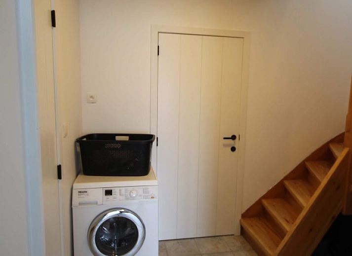 Geraeumiges Esszimmer im Huisje Nostalgie, Laakdal, Antwerpen, mit Holzmoebeln und moderner Beleuchtung.