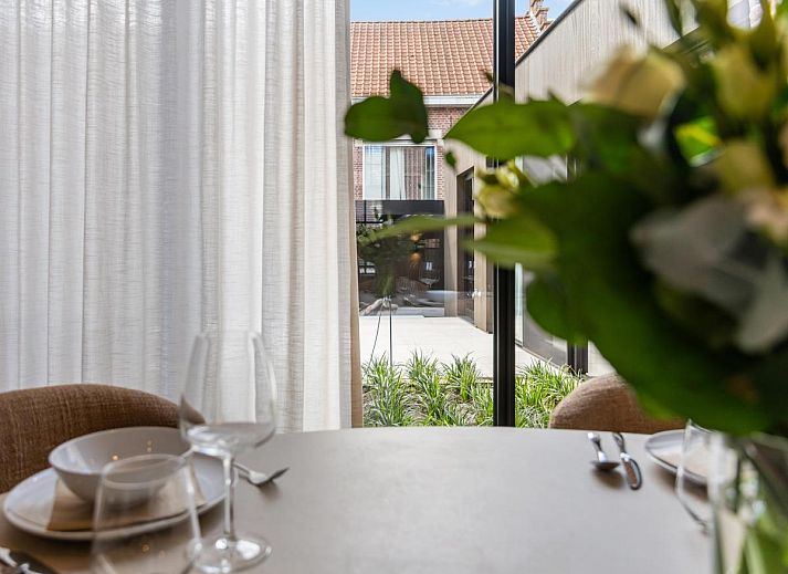 Gezellige veranda bij Pastorie Liezele, vakantiehuis in Puurs-Sint-Amands, Antwerpen, met moderne zitruimte en groene omgeving.