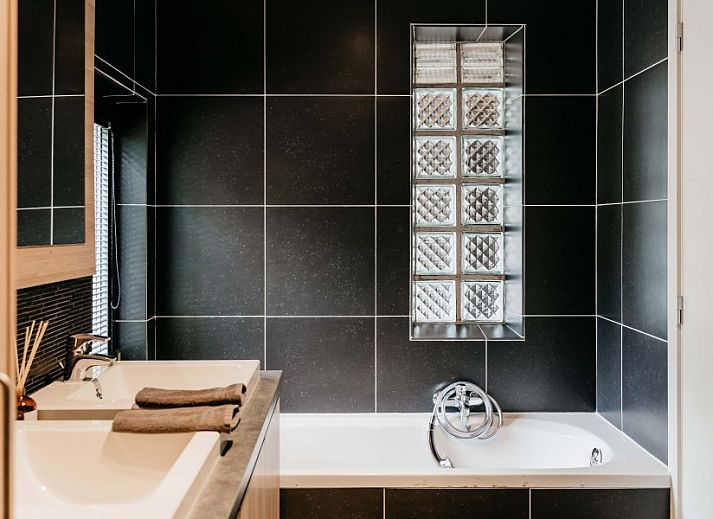 Gemuetliches Wohnzimmer im NatuRauw in Mol, Antwerpen, mit bequemer Sitzecke und grossen Fenstern.