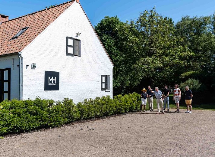 Mushoeve-Ferienhaus in Zoersel, Antwerpen mit gemuetlicher Sitzecke auf der Terrasse und gruenem Garten.