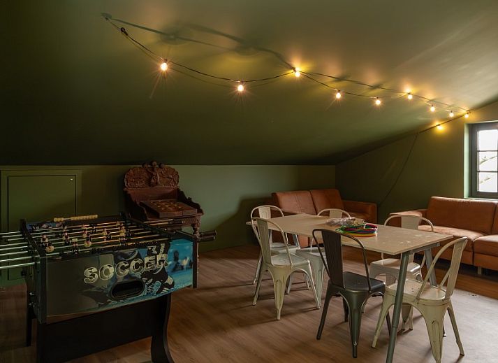 Interieur van Nachteneel De Paardenstal, vakantiehuis in Ravels, Antwerpen, Belgie, met lange tafel en stijlvolle hanglampen.
