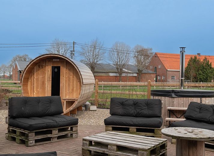 Grote ramen in Nachteneel De Paardenstal, vakantiehuis in Ravels, Antwerpen, Belgie, bieden uitzicht op groene omgeving en kunst aan de muur.