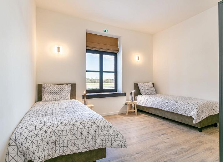 Cozy living room in Lindehoeve vacation home, Turnhout, with comfortable seating and wooden beams.