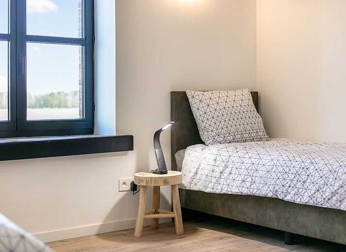 Cozy living room in Lindehoeve vacation home, Turnhout, with comfortable seating and wooden beams.