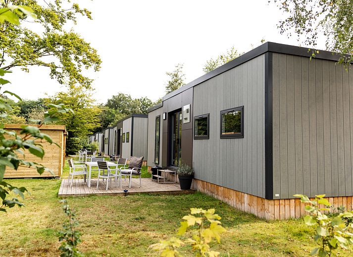 Modernes Interieur des Taos XL Delux Ferienhauses in Turnhout, Antwerpen mit heller Kueche und Blick auf den gruenen Garten.