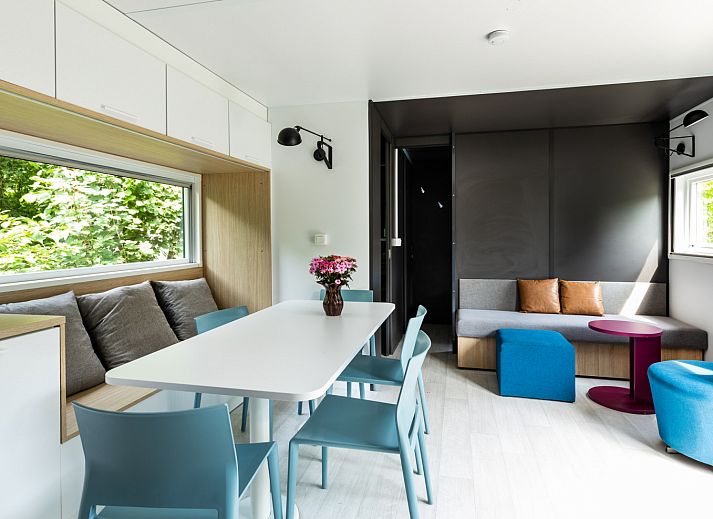 Modernes Interieur des Taos XL Delux Ferienhauses in Turnhout, Antwerpen mit heller Kueche und Blick auf den gruenen Garten.
