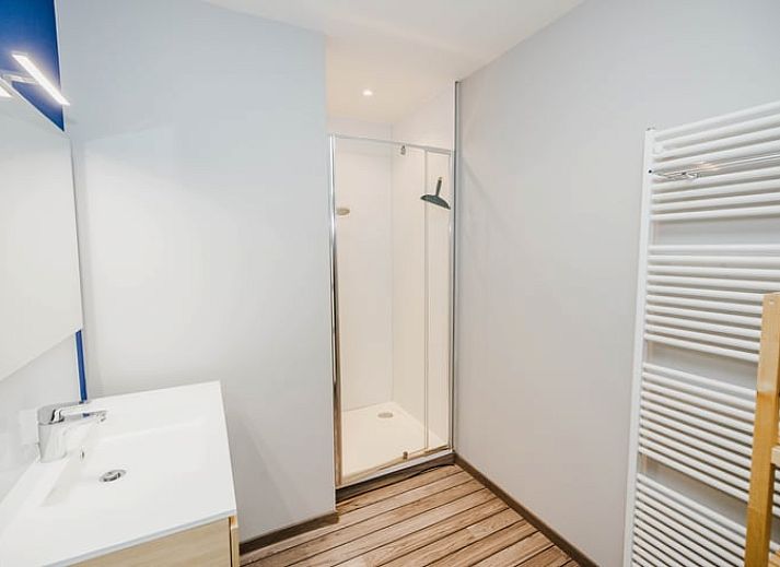 Gemuetliches Interieur des Huisje in Kasterlee, Antwerpen, mit einer niedlichen Regaldekoration auf einer orangefarbenen Bank.