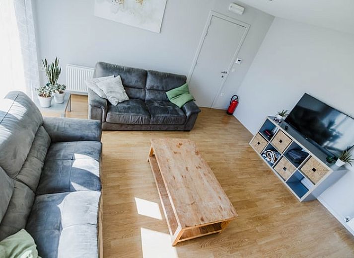 Gemuetliches Interieur des Huisje in Kasterlee, Antwerpen, mit einer niedlichen Regaldekoration auf einer orangefarbenen Bank.