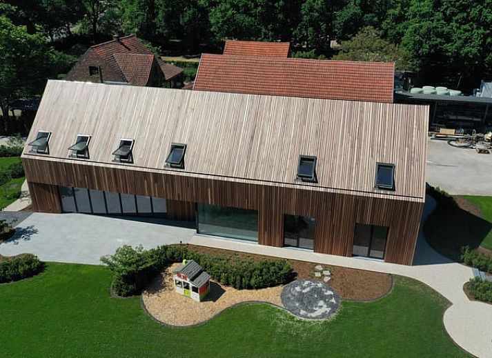 Ferienhaus in Kasterlee, modernes Ferienhaus in der gruenen Umgebung von Antwerpen, Belgien, mit grossem Garten und Holzfassade.