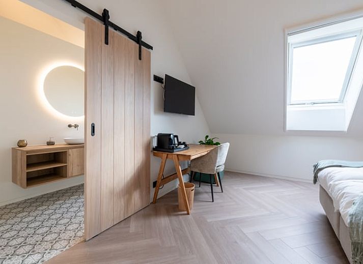 Beleuchtetes Aeusseres eines Ferienhauses in Kasterlee, das in der friedlichen Landschaft von Antwerpen, Belgien, liegt, bei Sonnenuntergang.