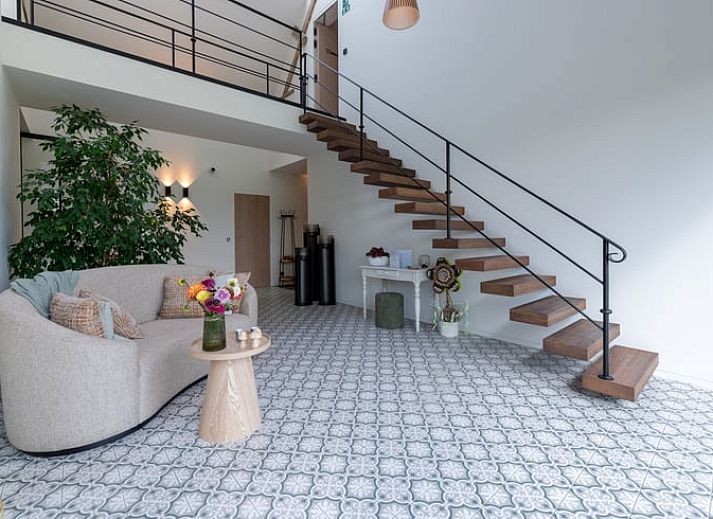 Gemuetlich beleuchtete Terrasse des Ferienhauses in Kasterlee, Antwerpen, Belgien, mit Blick auf die gruene Umgebung am Abend.